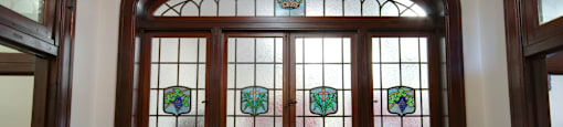 A stained glass window with a wooden frame and a white background.