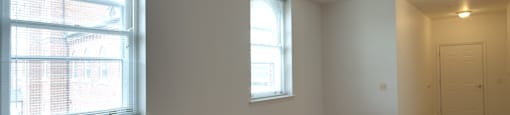A room with wooden floors and two windows.