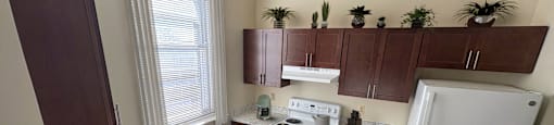 A kitchen with a white fridge and a bowl of apples on the counter.