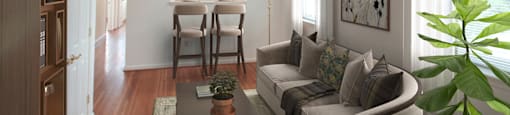 A living room with a couch, coffee table, and potted plant.