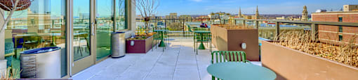 A patio with green chairs and a table is shown.