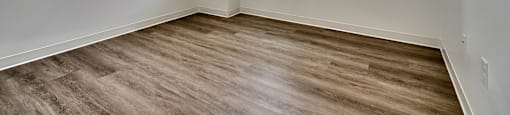 A room with a window and wooden flooring.