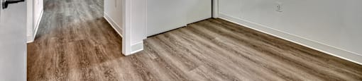 A room with a window and a wooden floor.