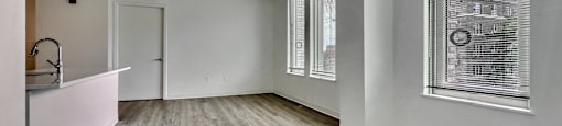 A room with a window and a wooden floor.