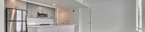 A kitchen with a refrigerator, microwave, and oven.