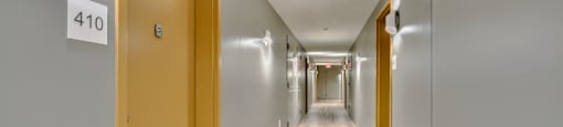 A long hallway with doors on either side and a sign that reads 410.