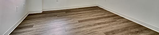 A room with wooden flooring and a window.
