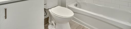 A white bathroom with a toilet, sink, and bathtub.