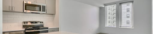 A kitchen with a white countertop and a microwave above it.