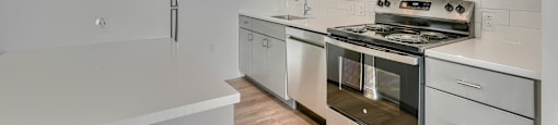 A modern kitchen with stainless steel appliances and white cabinetry.