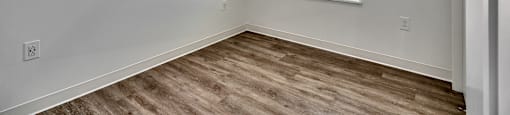 A room with a window and wooden flooring.