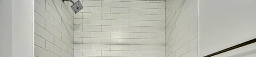 A white bathroom with a white tub and white tiles.