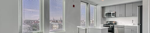 A modern kitchen with a view of the city through the windows.