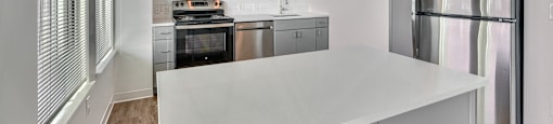 A modern kitchen with stainless steel appliances and a large island.