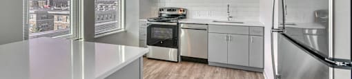 A modern kitchen with stainless steel appliances and a view of the city.