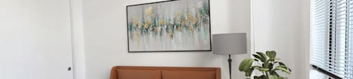 a bedroom with a bed and a painting on the wall