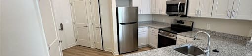A kitchen with a granite countertop and stainless steel appliances.