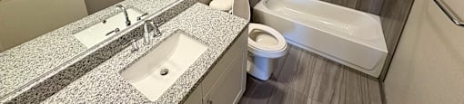 A bathroom with a sink, toilet, and bathtub.