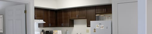 a kitchen with white appliances and dark wood cabinets