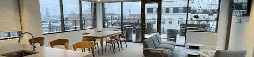 A modern office space with a kitchen area and seating.