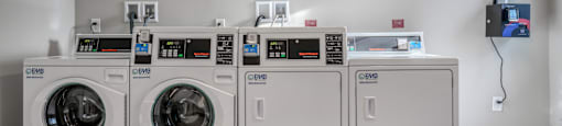 a row of washers and dryers in a laundry room