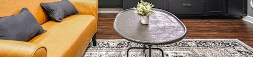 a kitchen and living room with yellow couches and a table