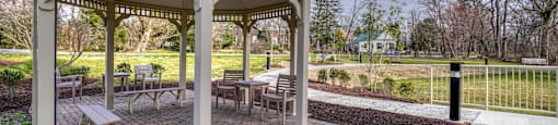 a gazebo with tables and chairs in a park