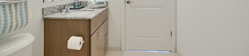 Now leasing senior 1-bedrooms in Baltimore, MD. A bathroom with a sink, mirror, and towel rack.