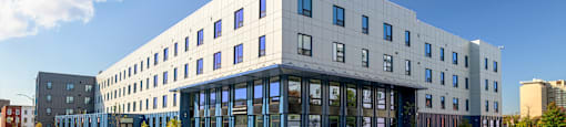 A modern building with a white facade and blue windows.