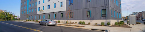 A modern building with a grey facade and blue sky in the background.