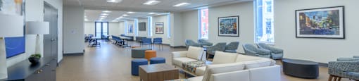 A spacious room with a variety of seating options and artwork on the walls.
