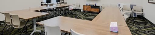 A conference room with a long table and chairs.