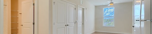 A kitchen area with a refrigerator, cabinets, and a window.