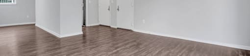 an empty living room with white walls and wood floors