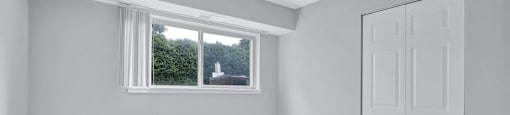 a white room with a window and a white door