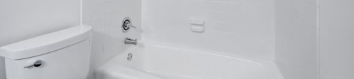 a white bathroom with a tub and a toilet