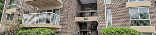 a building with two balconies and a sidewalk in front of it