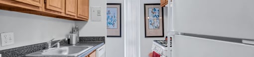 a kitchen with wood cabinets and granite counter tops and white appliances