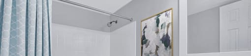 a white bathroom with a shower and a sink