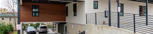 A modern building with a garage and a balcony.