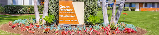 our sign in front of our home in the grass and palm trees