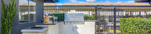 the backyard has an outdoor bar with a grill and a fence