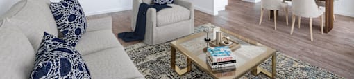 a living room with a couch a chair a table and a ceiling fan