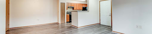 A spacious room with wood flooring and a ceiling fan.