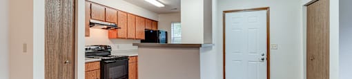 A kitchen with wood flooring and a white ceiling.