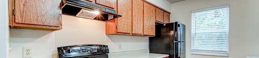 A kitchen with wooden cabinets and a black stove top oven.