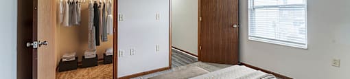 A bedroom with a bed, wardrobe, and a window.