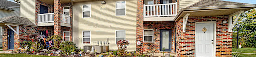 A two-story apartment building with a balcony on the second floor.