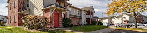 Apartment complex with a parking lot in front.