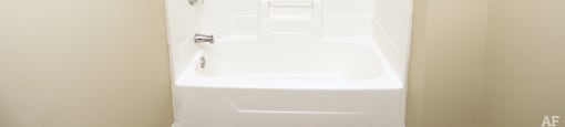 a bathroom with a white bathtub and a towel rack